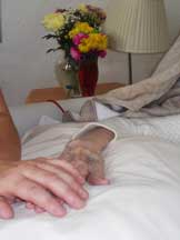 resident and carer holding hands