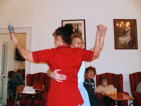 female carer and resident waltzing to the music